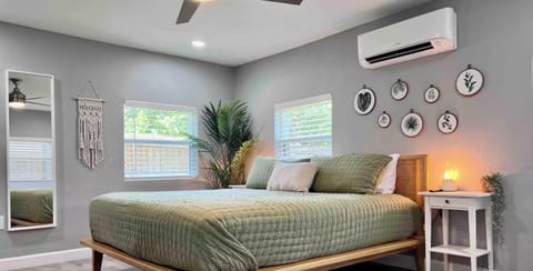 Bright modern king bedroom with warm decor and in-room AC