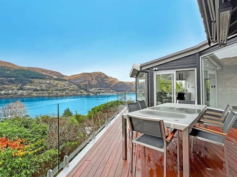 Private deck with outdoor dining, spa, and stunning views across Lake Wakatipu.