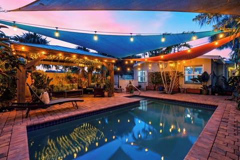 Poolside oasis with tropical landscaping and lounge seating.
