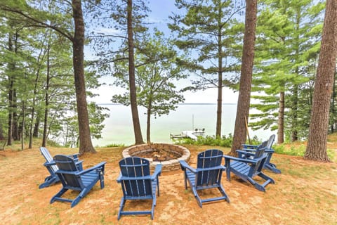Gather under towering pines around the stone fire pit with comfortable Adirondack chairs for cozy evenings, panoramic lake views, and pure relaxation right along the shore.