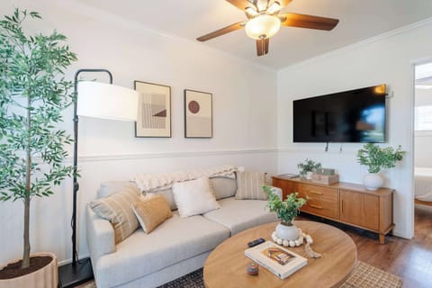 Bright and comfortable living room with cozy seating and a smart TV.