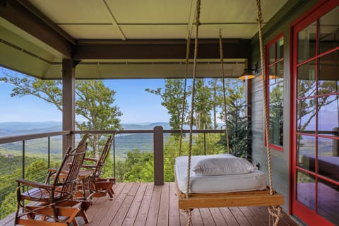 Claim the porch swing before anyone else does. Long-range Blue Ridge views stretch to the horizon from your own covered balcony, with rocking chairs waiting and nothing but mountain air and birdsong.
