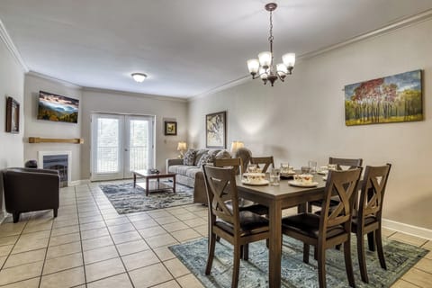 Living room, TV fireplace, tile floor. dining table. artwork.  double doorway.