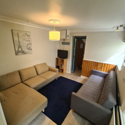 Cozy lounge with two sofas, TV, and warm, inviting decor