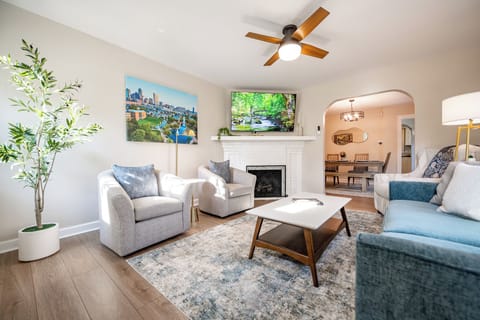 Bright living room with fireplace, TV, and open flow to dining area
