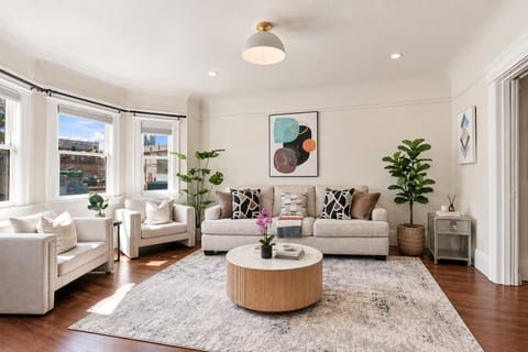 Sun-filled elegant living room with bay windows and cozy seating