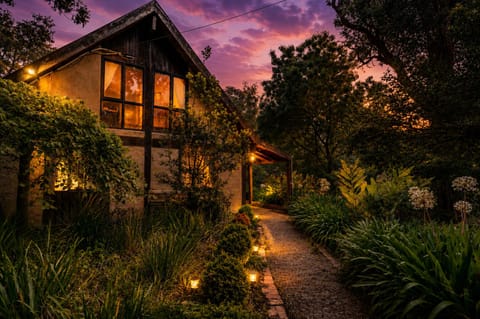 Enchanting garden cottage with warm glow and twilight path