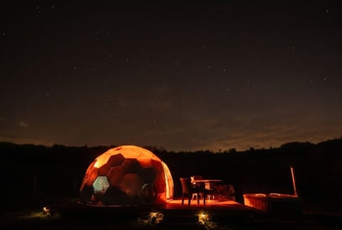 Sleep beneath a blanket of stars with your private hot tub glowing warm