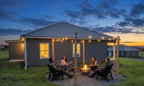Sunset hangout: fire pit, string lights, and wide-open country views.