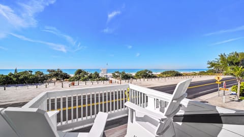 Sunny balcony with Adirondack chairs and sweeping ocean views