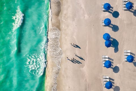 From above, the beach meets the Gulf waters in bands of blue.