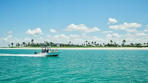 Glide along the coastline aboard a boat, open water stretching toward the horizon.
