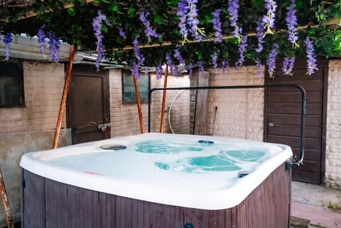 Bubbling hot tub under trailing blooms for evening soaks