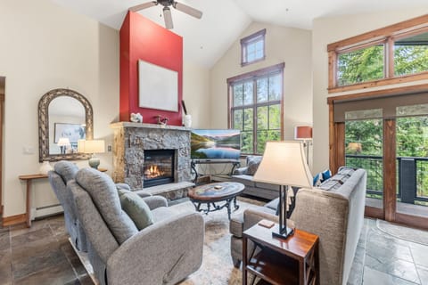 Sink into plush sofas by the stone fireplace and soak in sweeping mountain and lake views through floor-to-ceiling windows—your perfect retreat after a day of adventure.