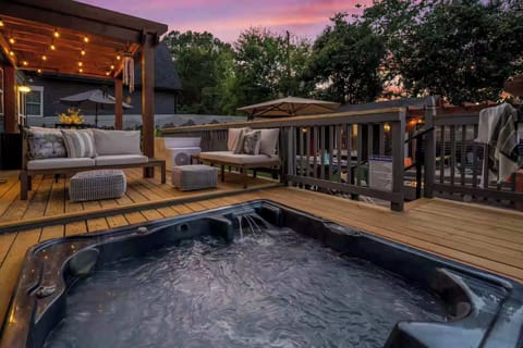 This is the photo you'll recreate on night one: jets on, waterfall running, sunset burning pink, string lights above, and the whole backyard to yourselves.