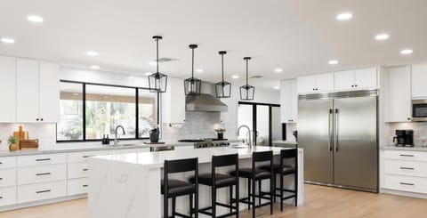 Bright designer kitchen with oversized island and seating for four