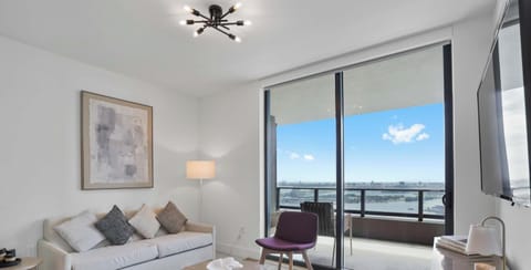 Bright living room with floor-to-ceiling windows and a private balcony.