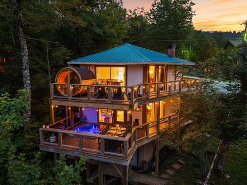 Forest cabin retreat with hot tub, sauna, and glowing wraparound decks