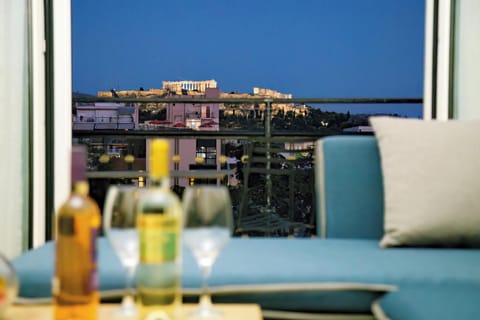 Enjoy a drink while gazing at the illuminated Acropolis