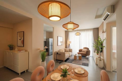 Spacious open-plan living and dining area featuring a dining table for six, a 2.2m sofa that can sleep one adult, a comfortable armchair, a 55-inch TV, and a fully equipped kitchen.