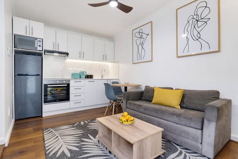 Modern studio with sleek kitchen, cozy sofa, and stylish open-plan living