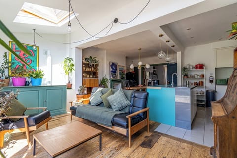 Sun-filled open living area with skylight, plants, and a stylish kitchen