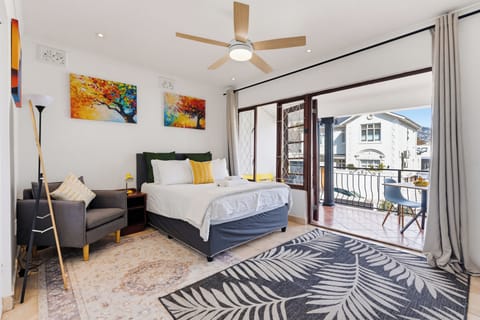 Bright bedroom with private balcony, outdoor seating, and stylish decor