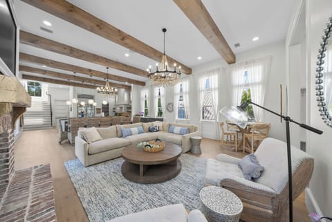 Step into your bright, airy living area with rustic beams, plush seating, and coastal charm perfect for unwinding or gathering with loved ones.