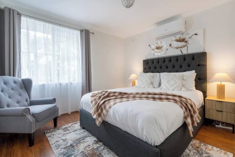 Located upstairs, the primary bedroom features a queen bed, cosy reading chair, ample storage, and split-system heating and cooling, creating a calm and restful retreat.