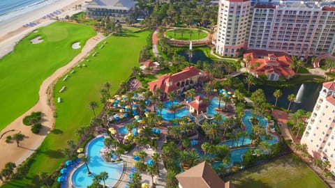 Aerial view of the pool complex with colourful umbrellas and palm trees