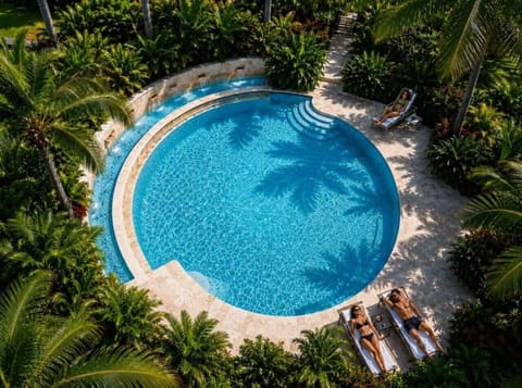Resort-style swimming pool surrounded by lush tropical landscaping.