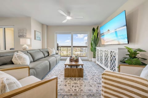 Unwind in the inviting living room at The Ormondy Unit B7, featuring stylish new furnishings, a large TV, and a comfortable reclining sofa, perfect for relaxing after a day by the coast