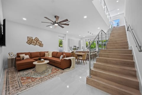 Spacious open-concept living room with sectional sofa and ceiling fan.