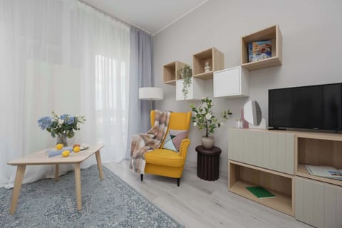 Another view of the studio showcasing the elegant living area, decorative shelving, and cozy seating corner.