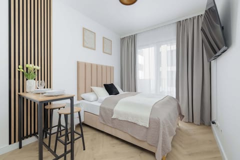 A bright and cozy bedroom with a comfortable A bright and cozy studio with a comfortable double bed and large windows that fill the space with natural light. It's a welcoming place to relax after a day of exploring.
