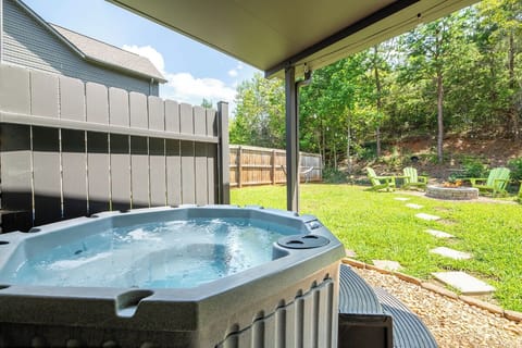 Slip into your private hot tub and let the warm jets melt away the day's stress, framed by lush green trees and a spacious backyard perfect for evening gatherings.