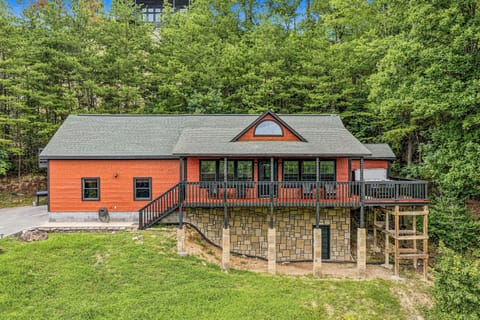 The property sits nestled among lush greenery, offering a peaceful mountain setting for your getaway. A spacious wraparound deck and stone-foundation lower level provide ample outdoor space to enjoy the surrounding forest.