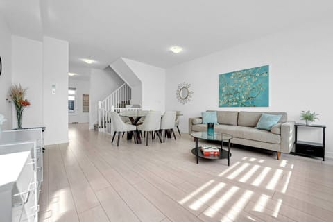 A bright, open-plan living and dining space with modern decor where you can host a movie night on the plush sofa or enjoy a family dinner.