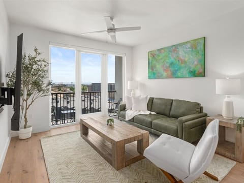 Beautifully designed living room. 75` TV, leather sofa and amazing views of mountains and city skyline.