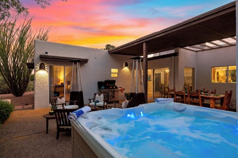 Soak beneath the sunset while the group enjoys outdoor dining, grilling, and fireside-style patio heaters nearby.
