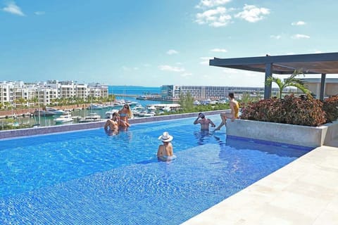 Rooftop infinity pool overlooking marina.