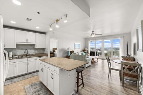 Bright, open-plan retreat with seamless kitchen-to-living flow. Modern white cabinetry, vaulted ceilings, and stylish island meet stunning waterfront views—perfect for morning coffee or sunset cocktails.