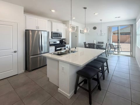 Kitchen with island, stools, stainless fridge, and microwave
