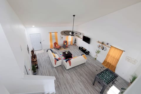 Bright open-concept living room with comfortable seating, Smart TV and foosball nearby. A welcoming place for families, construction crews, corporate travelers and insurance housing guests to relax during extended stays in Kyle, TX.