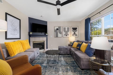 Bright, stylish living room with fireplace, TV, and cozy modern seating