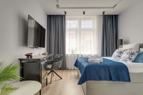 W pokoju znajduje się wygodne łóżko małżeńskie przygotowane z hotelową pościelą i kompletem poduszek oraz telewizor Smart TV z dostępem do kanałów satelitarnych. Do dyspozycji gości przygotowano również miejsce do przechowywania ubrań.
