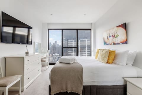 Wake to sweeping city views from the primary bedroom, styled with a king bed, mirrored wardrobe and private TV for effortless relaxation.