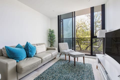 Sink into the plush sofa, stream a favourite show, or unwind with treetop views and soft afternoon light in the calming, open-plan living area.