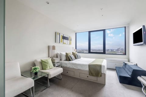 Come home to an inviting sleeping space with a comfortable queen bed, clever storage, and natural light streaming through large windows.