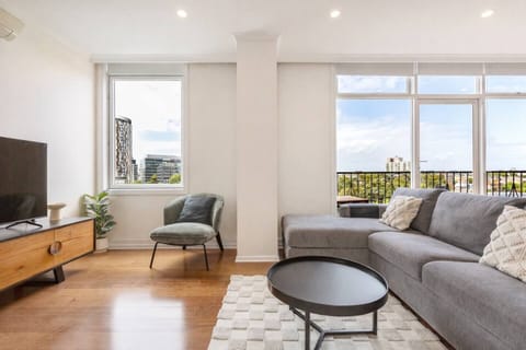 Unwind on the spacious L-shaped sofa as you take in sweeping city views through the floor-to-ceiling windows—perfect for movie nights or relaxing with a book in hand.